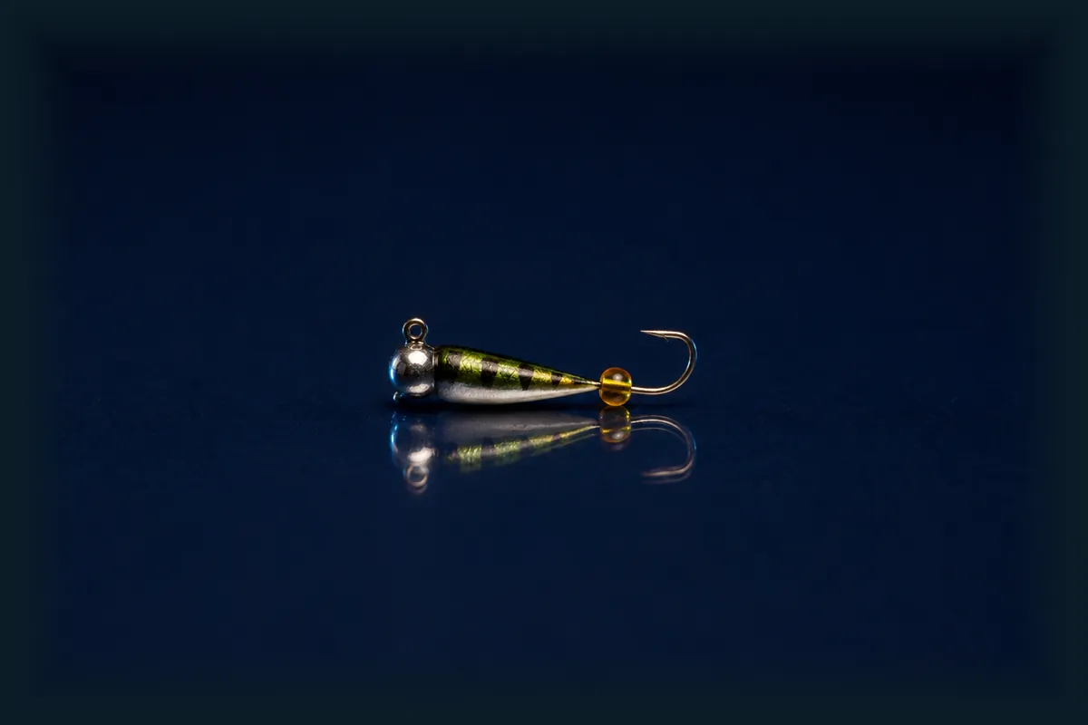 Ice jig fishing bait on a dark blue background